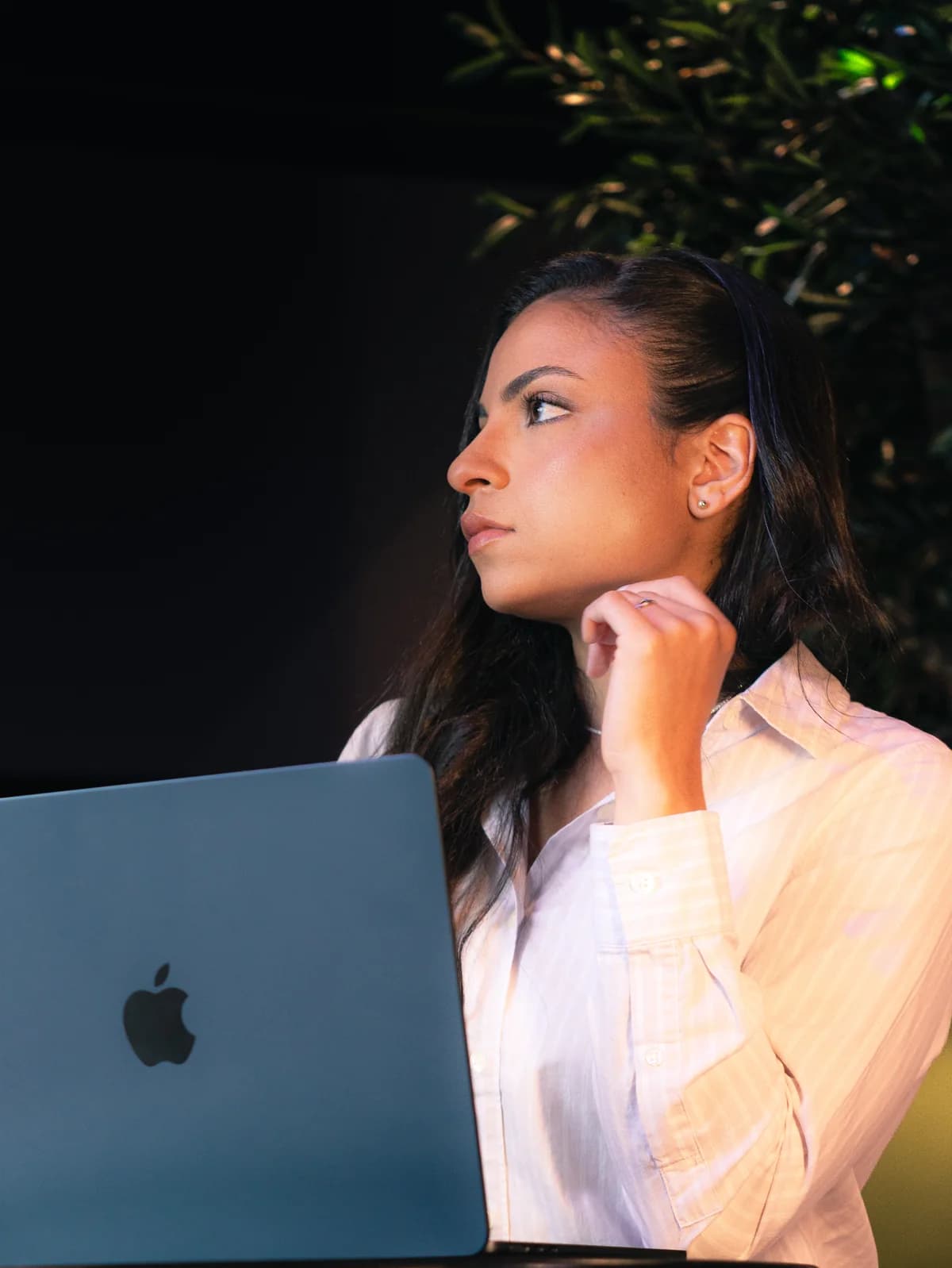 Juliana Queiroz de perfil, em frente ao notebook
